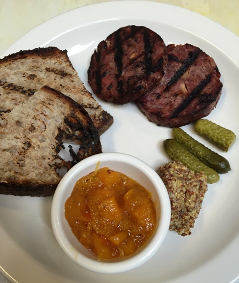 Grilled duck-pork sausage served with pumpkin confiture, cornichons, grain mustard and grilled country bread