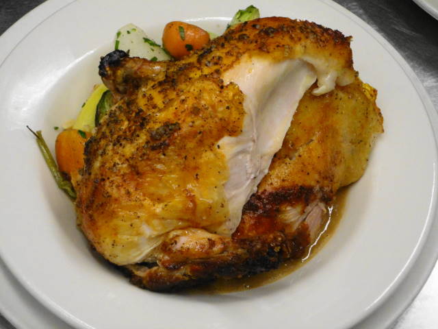 Whole roasted chicken for two served with roasted root vegetables, Brussels sprouts, and a walnut puree.