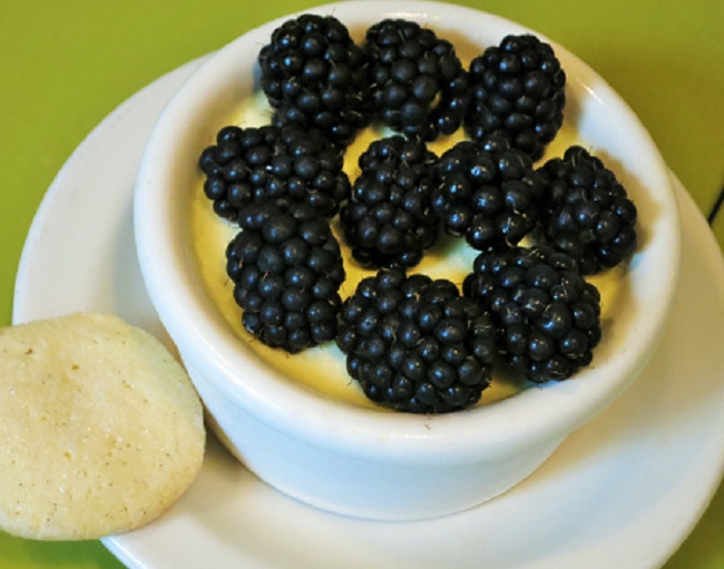 Lemon pot de creme served with fresh berries and a vanilla sablé  cookie.