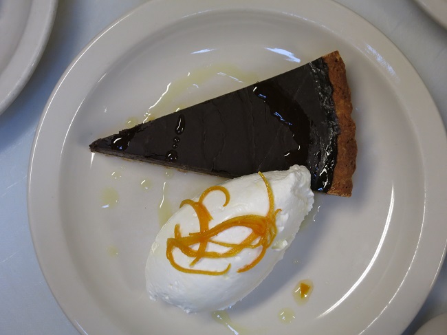 Chocolate-esspresso tart served with candied orange peel and whipped cream