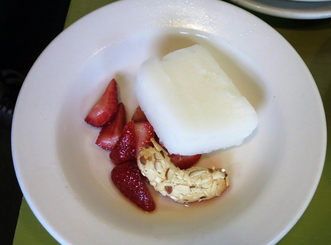 White wine-rose water sorbet terrine with honey-macerated strawberries and a corne de gazelle cookie.