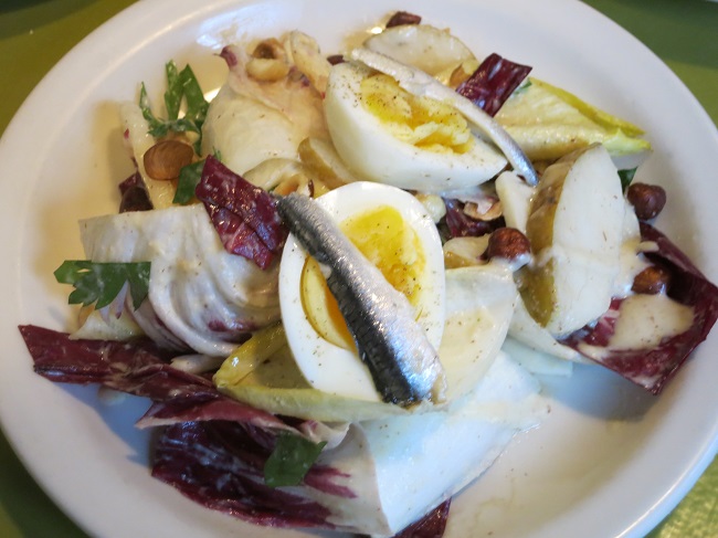 Salad of radicchio and Belgian endive, winter pears, hard cooked egg and vinegar cured anchovies.