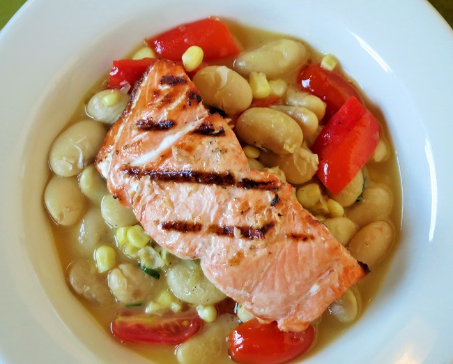 Wild caught salmon filet, smoked then grilled, on white beans simmered with cherry tomatoes, roasted red peppers, corn, basil and a sweet corn fumet