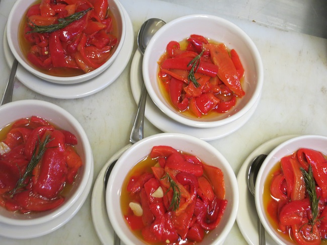 Marinated roasted red peppers ready for service.