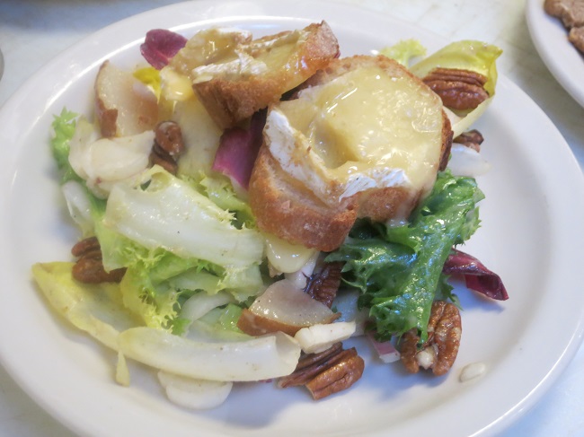 Salad of curly, red and Belgian endives tossed with honey roasted pears, pecans and roasted pear vinaigrette, topped with warm camembert croutons