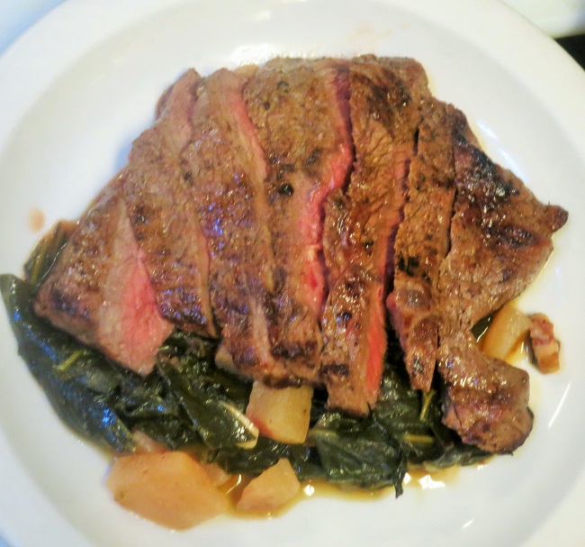 Grass fed petit sirlon steak served with collard greens braised with bacon, dark beer and quince and with pommes frites