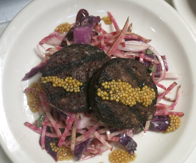 Grilled boudin noir served on a salad of raw chiogga beets, braised cabbage, tarragon and pickled mustard seeds