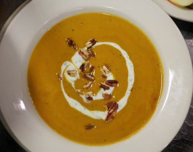 Curried yam soup served with cilantro creme fraiche and toasted pecans