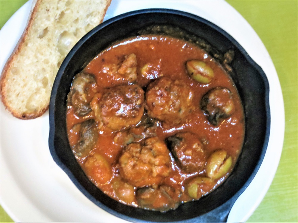 Pork-porcini meatballs and Burgundy snails simmered in a sauce with tomatoes, orange juice, green olives and rosemary, served with grilled baguette