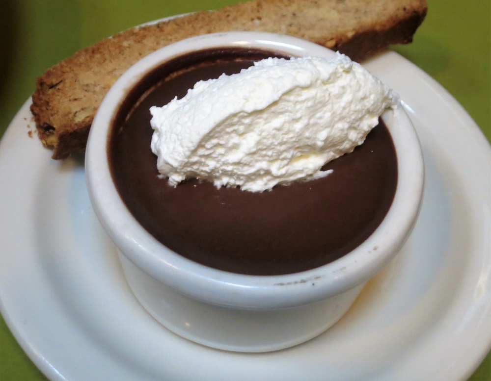 Chocolate-espresso pots de creme served with whipped cream and hazelnut biscotti